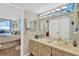 Well-maintained bathroom featuring blue-themed wallpaper, a large mirror, and cabinet storage at 5915 Sea Ranch Dr # 403, Hudson, FL 34667