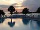 The community pool area at sunset with lounge chairs and lush landscaping at 5915 Sea Ranch Dr # 403, Hudson, FL 34667