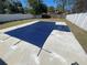 Backyard pool area showcasing the pool with a dark blue safety cover, surrounded by a patio area and fenced yard at 645 38Th S Ave, St Petersburg, FL 33705
