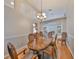 Elegant dining room featuring a wood table, decorative chandelier, and arched entryways at 7708 Nottinghill Sky Dr, Apollo Beach, FL 33572