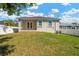 Backyard features a well-maintained lawn, a patio and the back of the house with white trim windows at 860 17Th S Ave, St Petersburg, FL 33701