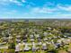 An aerial view of a quiet neighborhood featuring single Gathering homes, mature trees, and a small pond at 8621 Bridgewater Dr, New Port Richey, FL 34655