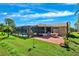 Lush backyard featuring a brick patio, screened lanai with a pool, and beautifully landscaped greenery at 8621 Bridgewater Dr, New Port Richey, FL 34655