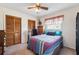 Bedroom with a ceiling fan, wood closet doors, and a colorful bedspread at 8621 Bridgewater Dr, New Port Richey, FL 34655
