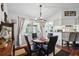 Bright dining room featuring a view into the kitchen, hardwood floors, modern lighting, and neutral paint at 8621 Bridgewater Dr, New Port Richey, FL 34655