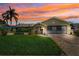 A single story home with lush landscaping and a paved brick driveway during sunset at 8621 Bridgewater Dr, New Port Richey, FL 34655