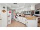 Well-lit kitchen featuring light-colored cabinets, granite countertops, and modern appliances overlooking living room at 8621 Bridgewater Dr, New Port Richey, FL 34655