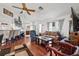 Bright living room featuring a ceiling fan, hardwood floors, comfortable seating, and large windows at 8621 Bridgewater Dr, New Port Richey, FL 34655