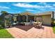 Expansive brick patio features outdoor seating and leads to a screened lanai with views of the lush backyard at 8621 Bridgewater Dr, New Port Richey, FL 34655