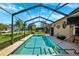 Sparkling swimming pool with screened enclosure, surrounded by patio space and green landscaping at 8621 Bridgewater Dr, New Port Richey, FL 34655