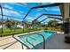 Inviting in-ground pool featuring a screened enclosure, clear blue water, and a sunny outdoor living space at 8621 Bridgewater Dr, New Port Richey, FL 34655