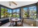 Bright sunroom with tile floors, large windows, and a charming dining set, perfect for enjoying the outdoor views at 8621 Bridgewater Dr, New Port Richey, FL 34655