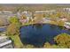 Aerial view of property, with a lake and nearby shopping, set amongst lush greenery and residential buildings at 10423 Carrollbrook Cir # 102, Tampa, FL 33618
