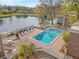 Community pool area featuring lounge chairs with a view of the lake, and stairs for access to the deck above at 10423 Carrollbrook Cir # 102, Tampa, FL 33618