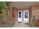 Front door entrance featuring neutral brick, two white doors, and potted cactus at 10423 Carrollbrook Cir # 102, Tampa, FL 33618