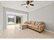 Bright living room featuring a tan sofa, tile floors, and a large sliding door to a beautiful view at 10423 Carrollbrook Cir # 102, Tampa, FL 33618