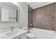 Neutral toned bathroom features shower and tub with tile surround and vanity sink and toilet at 10906 Johanna Ave, Riverview, FL 33578