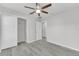 This bedroom features light gray walls, wood-look flooring, a closet, a ceiling fan, and two doors at 10906 Johanna Ave, Riverview, FL 33578