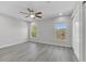 Spacious bedroom with wood-look floors, a ceiling fan, and two large windows overlooking the lake at 10906 Johanna Ave, Riverview, FL 33578