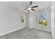 Bedroom featuring neutral paint, wood-look floors, a modern fan, and natural light from two windows at 10906 Johanna Ave, Riverview, FL 33578