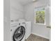 A clean laundry room featuring a modern washer and dryer set with shelving above at 10906 Johanna Ave, Riverview, FL 33578