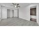 Large main bedroom with wood-look floors, a ceiling fan, and an en-suite bathroom with a tiled shower/bath combo at 10906 Johanna Ave, Riverview, FL 33578