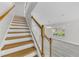 Staircase with wood steps, white risers, and white railing leading to the upper level at 10906 Johanna Ave, Riverview, FL 33578