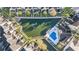 Aerial view showcases townhouses surrounding a pond with a fountain and a community pool with surrounding palm trees at 12253 Armenia Gables Cir # 12253, Tampa, FL 33612