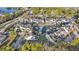Aerial view showcasing waterfront townhouses within a community surrounded by lush greenery and nearby lake at 12253 Armenia Gables Cir # 12253, Tampa, FL 33612