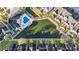 Aerial view of townhouses surrounding a pond with a fountain and a community pool with nearby palm trees at 12253 Armenia Gables Cir # 12253, Tampa, FL 33612