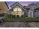 Inviting condo exterior with a large arched window and well-manicured lawn at dusk at 12253 Armenia Gables Cir # 12253, Tampa, FL 33612