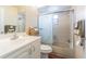Bathroom showcasing a vanity with cabinets and tub-shower with a sliding glass door, blending utility with style at 1232 Persimmon Dr, Holiday, FL 34691