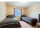 Cozy bedroom featuring two twin beds, neutral walls, ceiling fan and ample natural light from the window at 1232 Persimmon Dr, Holiday, FL 34691