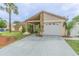 Charming single-story home with stone accents, a well-manicured lawn, and a concrete driveway leading to an attached garage at 1232 Persimmon Dr, Holiday, FL 34691