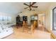 Open living area with wood floors, ceiling fan, and lots of natural light at 1232 Persimmon Dr, Holiday, FL 34691