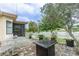 A brick patio features a fire pit, table and chairs, and a white picket fence at 1232 Persimmon Dr, Holiday, FL 34691