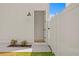 Backyard entrance featuring a white fence, a step-stone path, and a wall-mounted lamp at 1239 36Th N Ave, St Petersburg, FL 33704