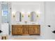 Bright bathroom featuring a walk-in shower, double vanity with marble countertop and light wood cabinets at 1239 36Th N Ave, St Petersburg, FL 33704