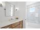 Bathroom with marble countertop, wood cabinets, decorative mirror, and a glass-enclosed tub and shower at 1239 36Th N Ave, St Petersburg, FL 33704
