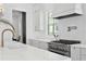 Bright kitchen featuring stainless steel appliances, white cabinets, and marble countertops at 1239 36Th N Ave, St Petersburg, FL 33704
