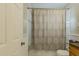 Neutral colored bathroom with a tub and shower combination, decorative shower curtain, and storage at 129 18Th N Ave, St Petersburg, FL 33704