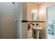 Cozy bathroom features tiled walls, a pedestal sink, and a walk-in shower, offering comfort and style at 129 18Th N Ave, St Petersburg, FL 33704