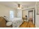 Comfortable bedroom with hardwood floors, a ceiling fan, and a doorway to an adjacent room at 129 18Th N Ave, St Petersburg, FL 33704