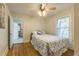 Cozy bedroom featuring hardwood floors, a ceiling fan, and a doorway to an adjacent room at 129 18Th N Ave, St Petersburg, FL 33704