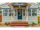 Welcoming front porch featuring a brick stairway, blue door, and ample natural light at 129 18Th N Ave, St Petersburg, FL 33704