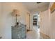 Hallway with neutral walls leading to the kitchen; features a decorative cabinet and lamp at 129 18Th N Ave, St Petersburg, FL 33704