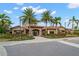 Community building with tile roof, lush landscaping, and palm trees at 13714 Messina Loop # 101, Bradenton, FL 34211