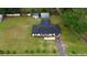 Aerial view of charming home on a large lot, featuring two outbuildings, a driveway, and well-maintained landscaping at 1413 Lithia Pinecrest Rd, Brandon, FL 33511