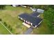Aerial view of charming home on a large lot, featuring two outbuildings, a driveway, and landscaping at 1413 Lithia Pinecrest Rd, Brandon, FL 33511