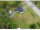 Aerial view of charming home on a large lot, featuring two outbuildings, a driveway, and landscaping at 1413 Lithia Pinecrest Rd, Brandon, FL 33511